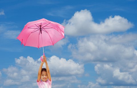 Mary Poppins girl with umbrella in front of blue sky