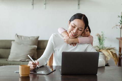 Happy mother working from home with her daughter