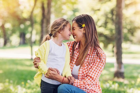 Happy girl with smiling nose-kissing aupair lady